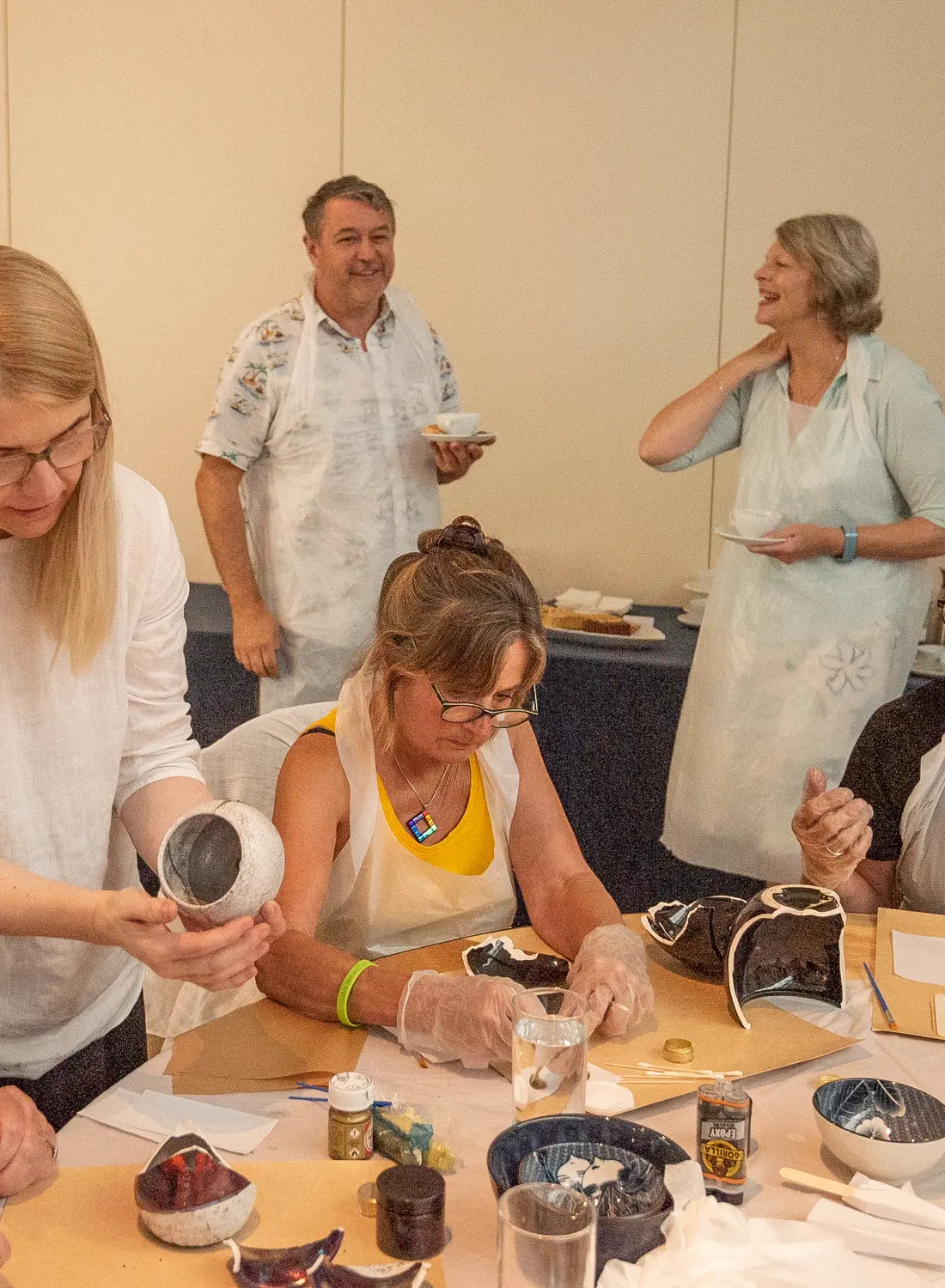 Hands carefully repairing a ceramic piece during a Kintsugi team workshop
